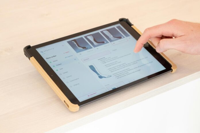 seseorang yang menggunakan tablet di atas meja