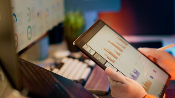 Seseorang menganalisis data keuangan di tablet.